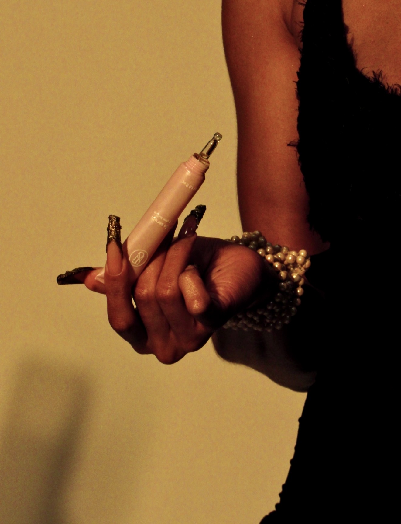 Editorial close-up of hand holding Glowé cuticle serum